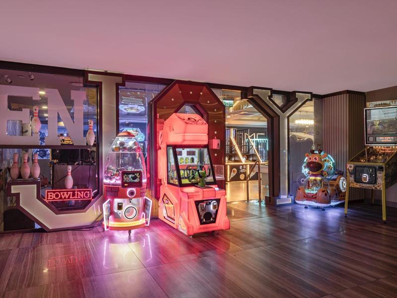 Interno con macchine arcade e flipper in un hotel o area ricreativa.