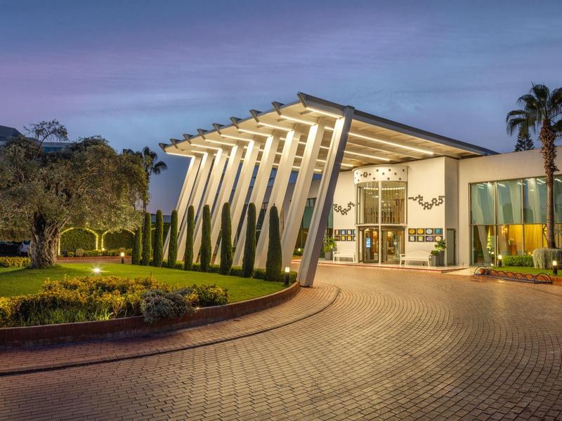 Hotel moderno con architettura sorprendente e giardino anteriore curato al crepuscolo.