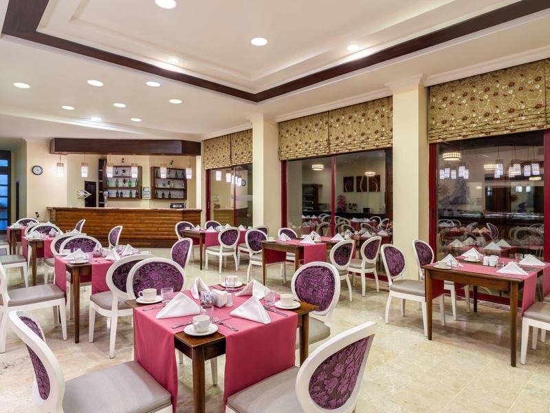 Ristorante elegante con sedie rotonde e tavoli apparecchiati sotto luce calda.