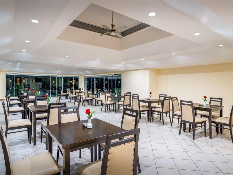 Sala da pranzo moderna e luminosa con pareti bianche e mobili in legno scuro.