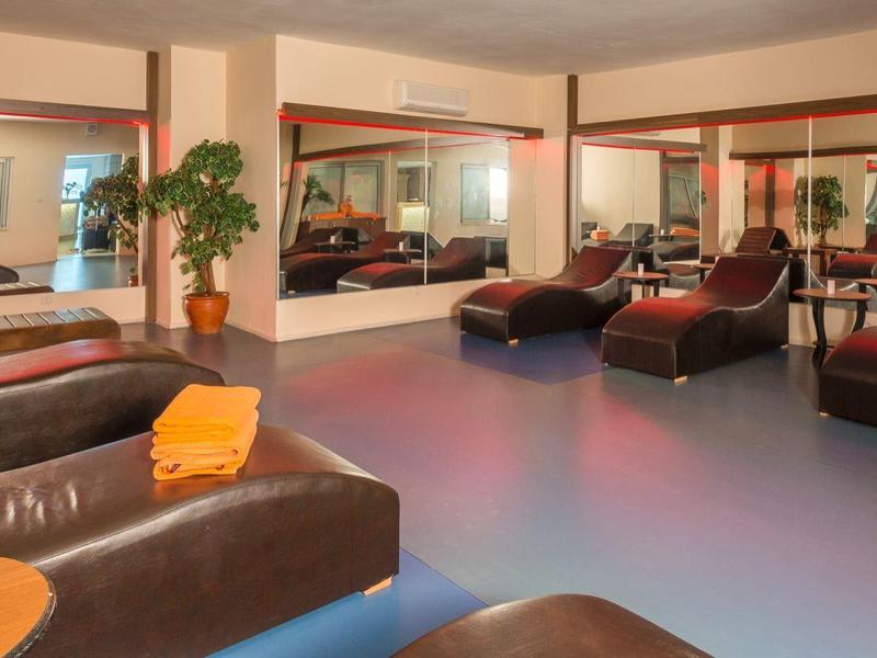 Ampia zona lounge moderna dell'hotel con divani in pelle scura e piante.