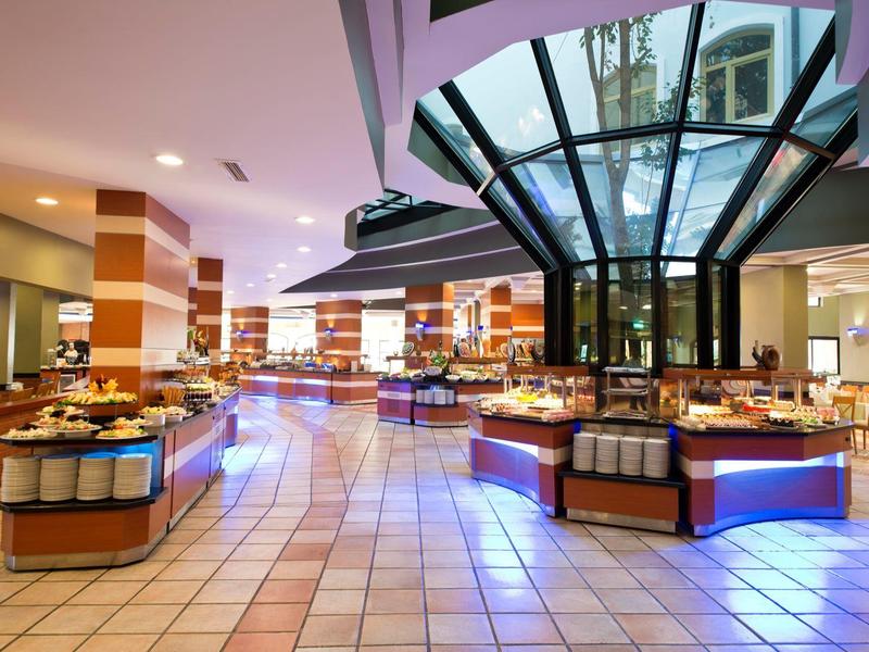 Area buffet elegante del ristorante dell'hotel con illuminazione da palco e tavoli apparecchiati