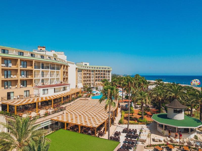Complesso alberghiero con piscina, terrazza e vista sul mare sotto un cielo limpido.