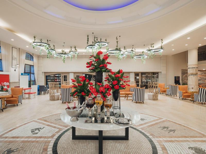 Elegante hall dell'hotel con interno luminoso, disposizione floreale e aree salotto confortevoli.