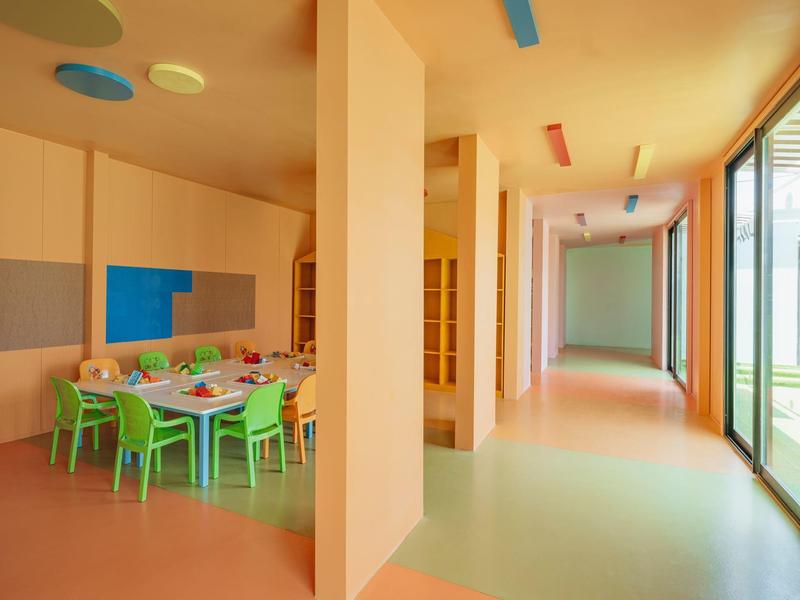 Sala da pranzo moderna con sedie colorate e grandi finestre in un hotel.