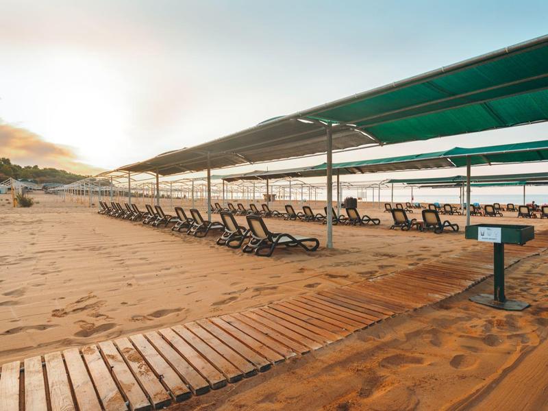 Spiaggia con lettini e ombrelloni al tramonto vicino al mare
