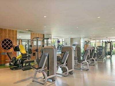 Palestra moderna con diverse macchine per esercizi e molta luce naturale.