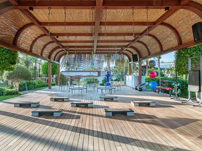 Area esterna coperta con posti a sedere e vista sulla piscina in un hotel.