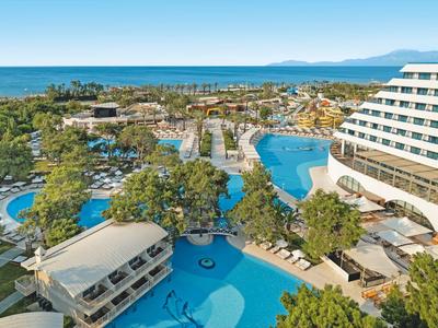 Großes Hotelresort mit mehreren Pools, Palmen und Blick auf das Meer.