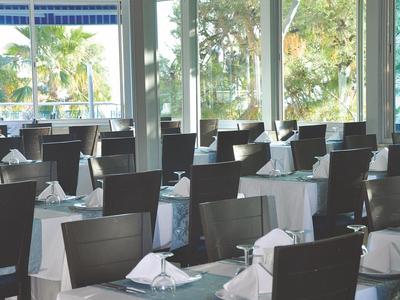 Ristorante elegante con tovaglie bianche e blu e vista sul verde.