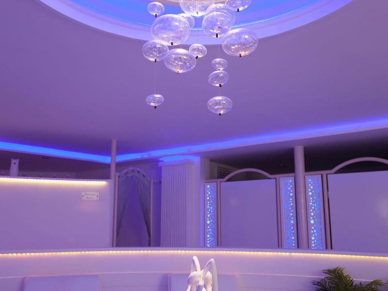 Interno moderno con lampadario artistico e illuminazione elegante in un ambiente luminoso