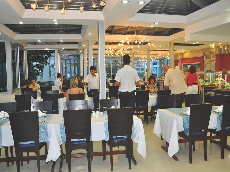 Un ristorante elegante con tavoli apparecchiati e ospiti sullo sfondo.