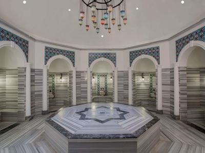 Interiér hammamu s mramorovými zdmi a centrální vodní nádrží.