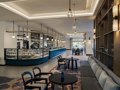 Moderní hotelová lounge s elegantním posezením a osvětleným barem.