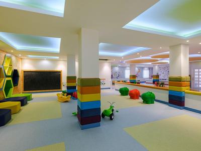 Jasně osvětlená barevná dětská herna v hotelu s polštáři a hračkami