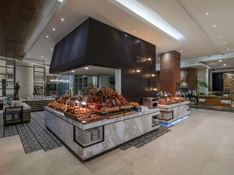 Luxusní hotelový interiér s elegantními mramorovými stojany a zakrytými pokrmy.