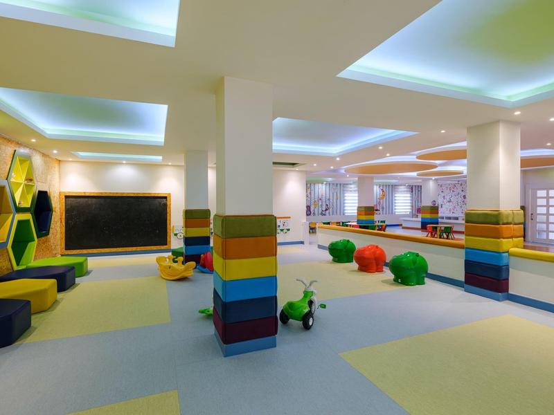 Jasně osvětlená barevná dětská herna v hotelu s polštáři a hračkami