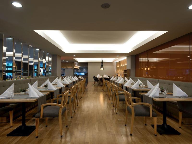 Ristorante moderno ed elegante con pavimenti in legno e tavoli elegantemente apparecchiati.