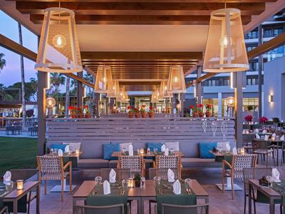 Ristorante all'aperto coperto con soffitto in legno e illuminazione accogliente al crepuscolo.