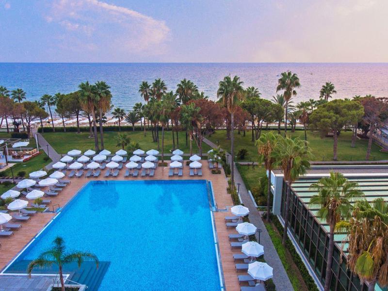 Vista di un'ampia area piscina dell'hotel con lettini e ombrelloni vicino al mare.