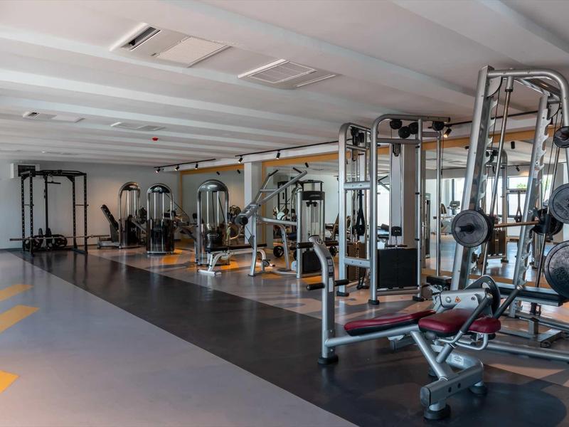 Spacious gym with various strength and cardio equipment in a hotel.