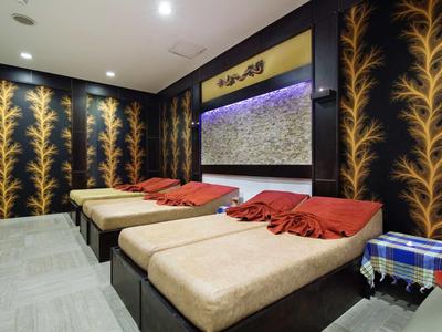 Cozy hotel spa room with comfortable lounge beds and warm lighting.