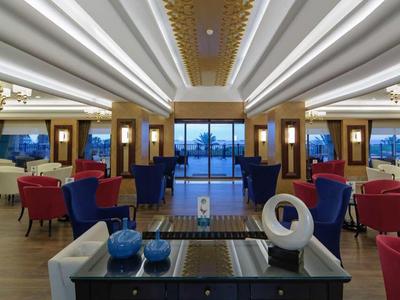 Spacious, modern lounge with elegant seating, ambient lighting, and a view of the ocean through large windows.