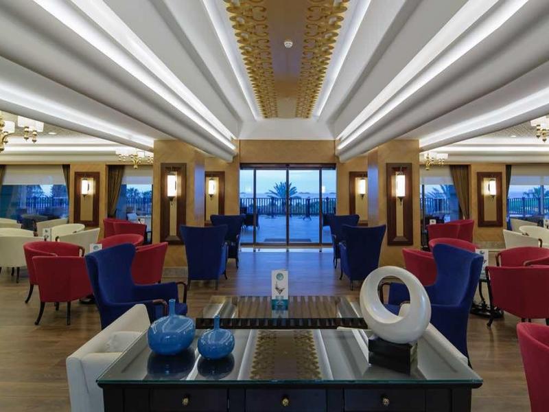 Spacious, modern lounge with elegant seating, ambient lighting, and a view of the ocean through large windows.