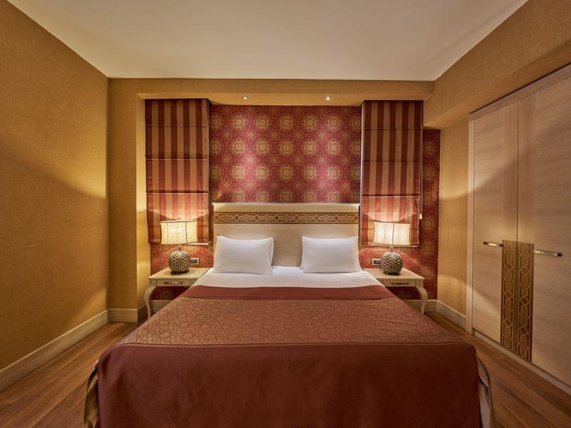 Gemütliches Hotelzimmer mit Doppelbett, Nachttischen und warmem Licht.