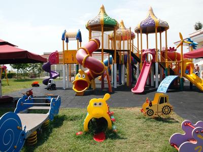 Bunter Kinderspielplatz im Freien mit Rutschen und Klettergerüsten in Hotelumgebung.