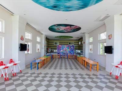 Heller Speisesaal mit buntem Wandbild und vielen Stühlen, geeignet für Hotelgäste.