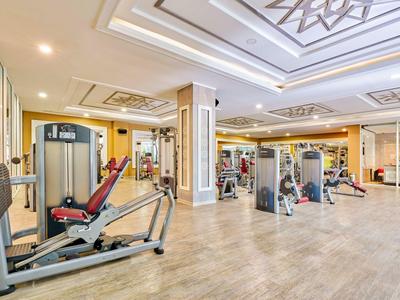 Geräumiger Fitnessraum mit modernen Geräten und heller Beleuchtung in einem Hotel.