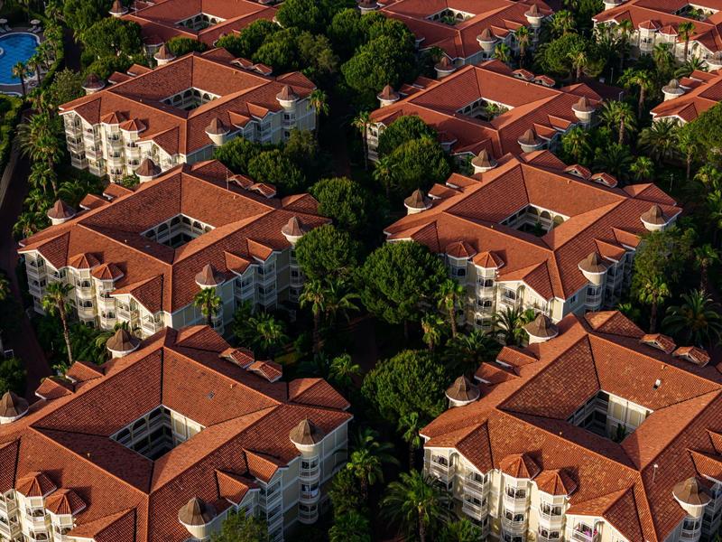 Aerial view of a resort with several buildings surrounded by trees and greenery.