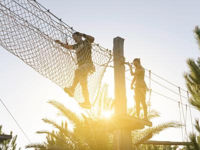 Due persone che scalano in un percorso sospeso al tramonto