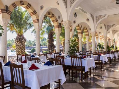 Ristorante elegante con tovaglie bianche e vista su palme e acqua