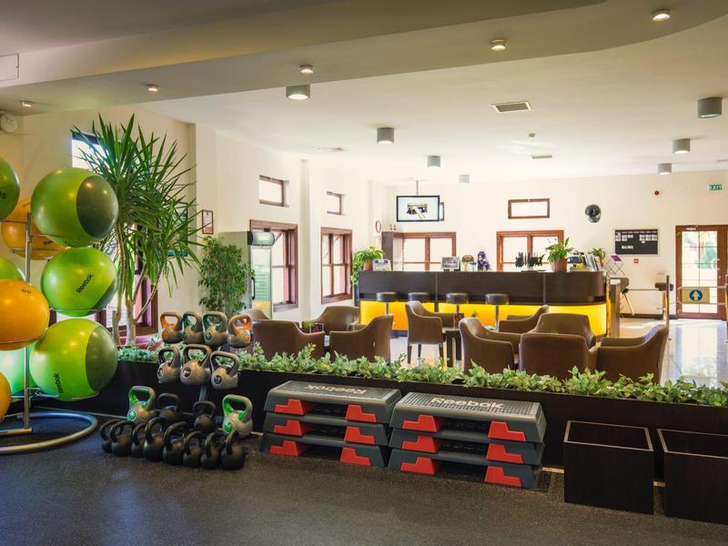 Ampia hall dell'hotel con banco reception, divani e piante decorative.