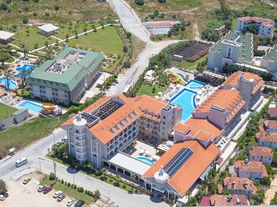 Großes Hotel mit roten Dächern, Pools und grünen Flächen, umgeben von Straßen und Wohnhäusern.