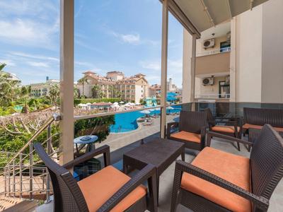 Balcone con zona salotto con vista sulla piscina in un resort hotel.