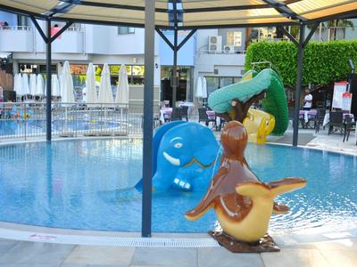 Area giochi per bambini con giochi d'acqua colorati accanto alla piscina esterna dell'hotel