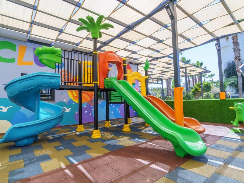 Area giochi colorata per bambini con scivoli sotto una zona coperta in un hotel