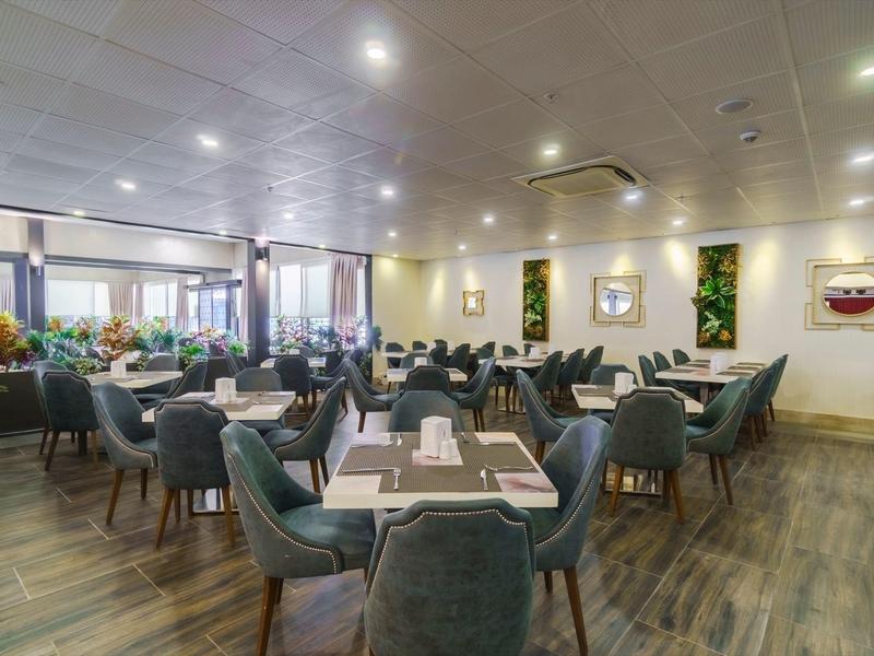 Sala da pranzo moderna e ben illuminata con tavoli eleganti e sedie confortevoli.