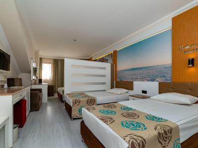Hotelzimmer mit zwei Einzelbetten, hellem Holz, großem Wandbild und modernem, schlichtem Design.