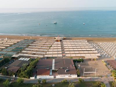 Aerial view of a beach with rows of umbrellas and a view of the sea.