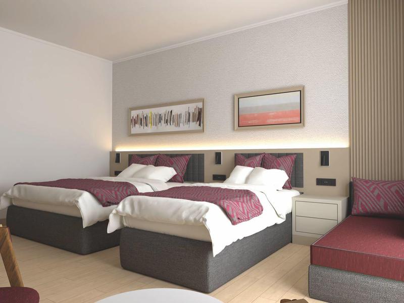 Modern hotel room with two single beds, nightstands, and a seating area with a cushioned bench.