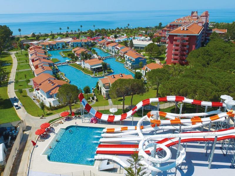 Aerial view of a resort featuring large water slides, multiple pools, and proximity to the sea.
