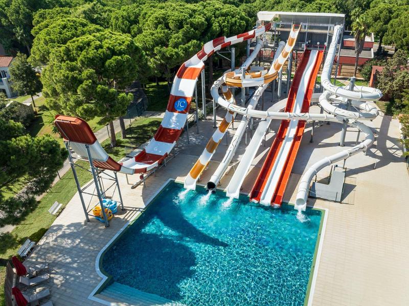 Several colorful water slides leading into a large swimming pool in a water park.