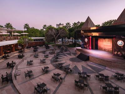 View of an outdoor area with numerous chairs and a stage area at sunset.