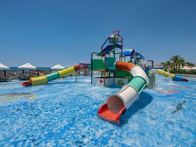 Water slide and playground in a pool area of a holiday resort on a sunny day.