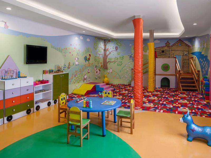 Kids' room with colorful furniture, toys, and climbing area in a hotel