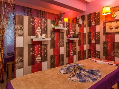 Una stanza massaggi accogliente con luci calde e pareti colorate e decorate.